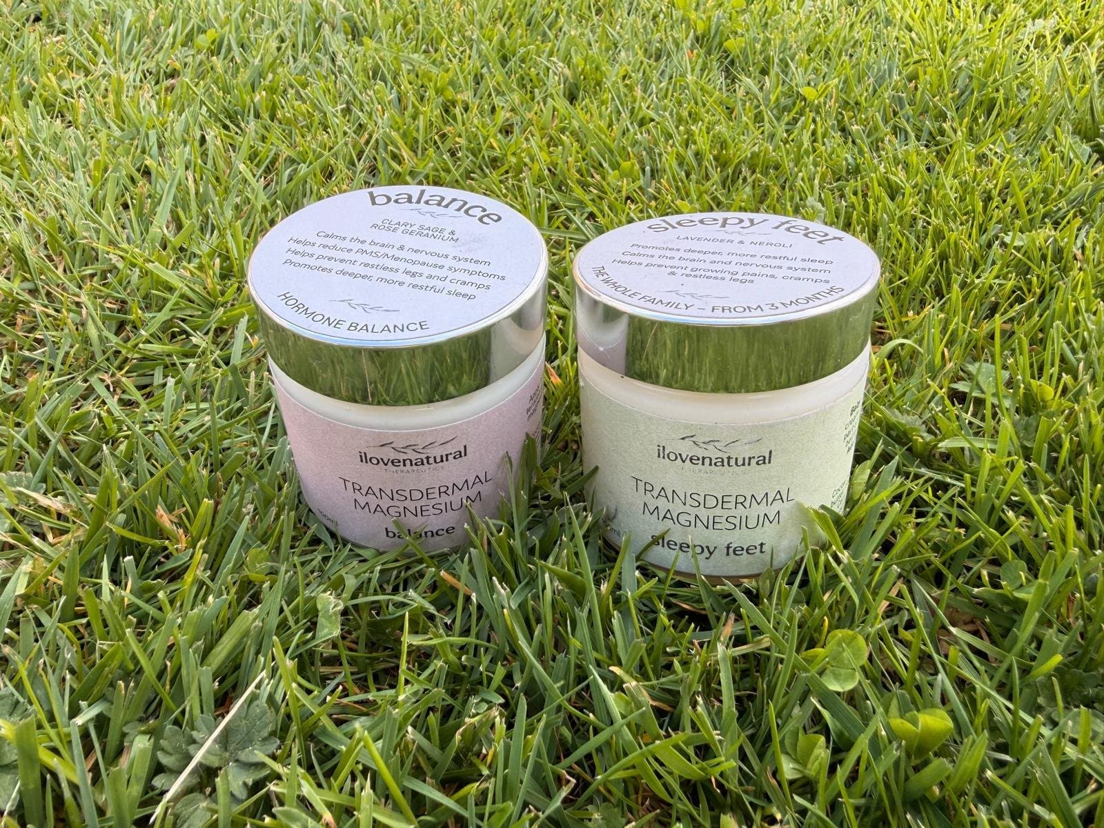 Magnesium cream tins resting on grass in soft light